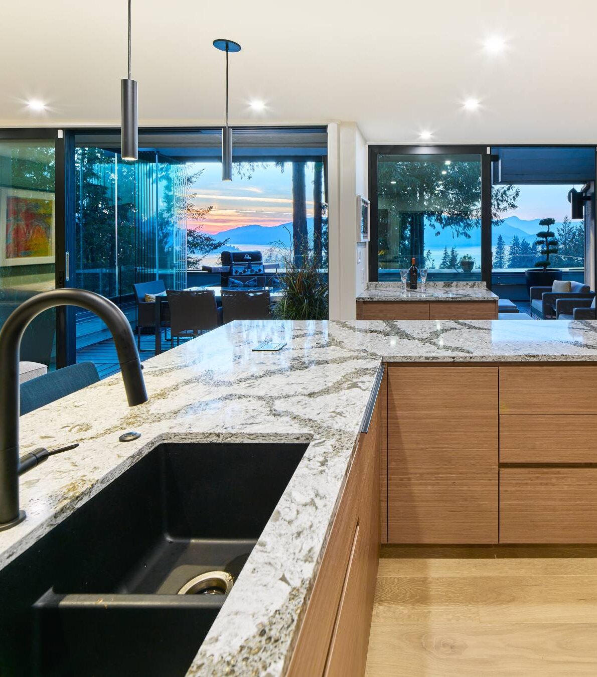 West Vancouver Rebirth: rift oak kitchen with waterfall counters and multi-slide patio doors